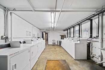 A large industrial room with white walls and a yellow mat on the floor.